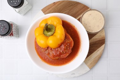 Photo of Delicious stuffed bell pepper served on white tiled table, flat lay