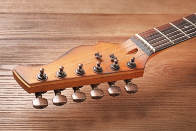 Modern electric guitar on wooden background, closeup view. Musical instrument