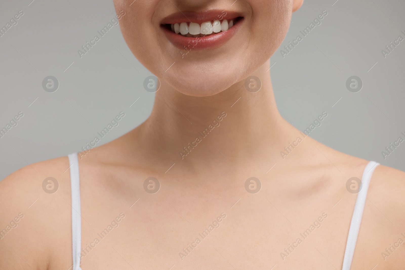 Photo of Beauty concept. Smiling woman on grey background, closeup