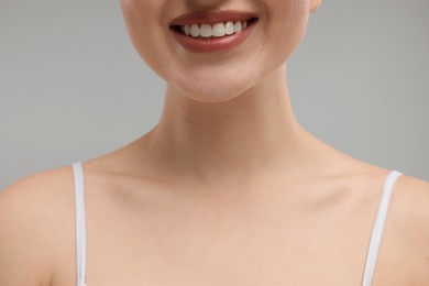 Beauty concept. Smiling woman on grey background, closeup