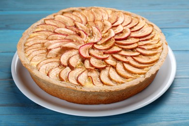 Photo of Tasty apple pie on light blue wooden table