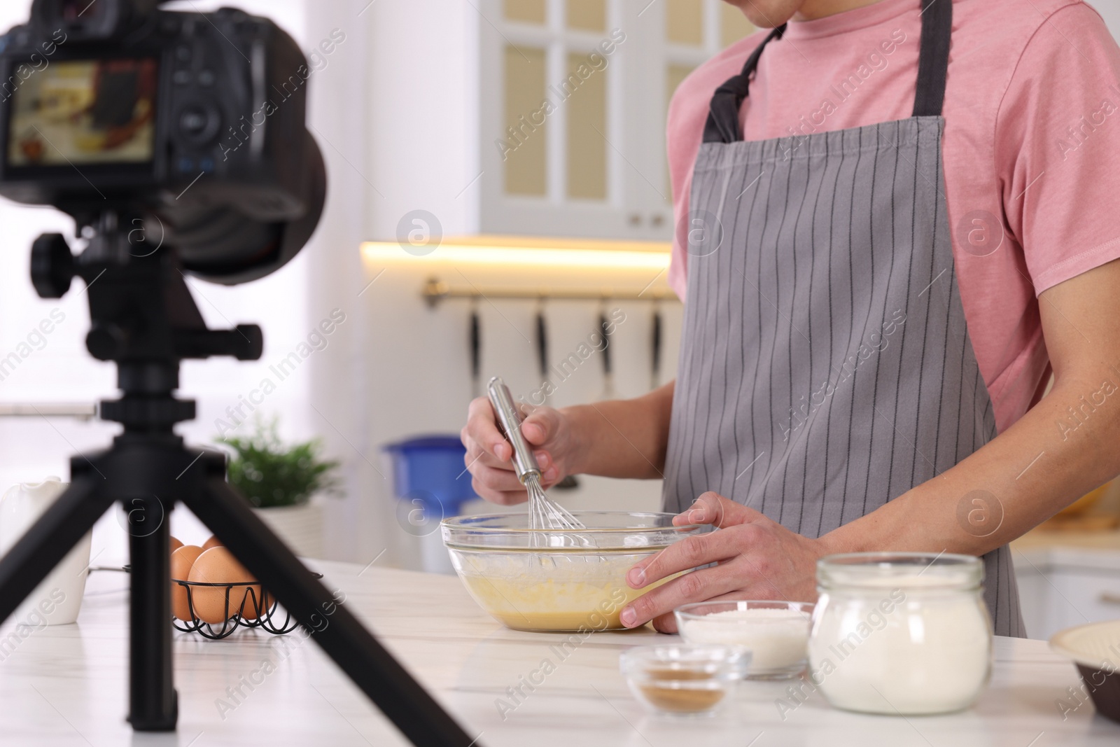 Photo of Food blogger cooking while recording video in kitchen, closeup