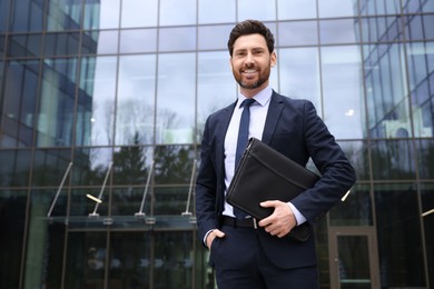 Photo of Real estate agent with leather portfolio outdoors. Space for text