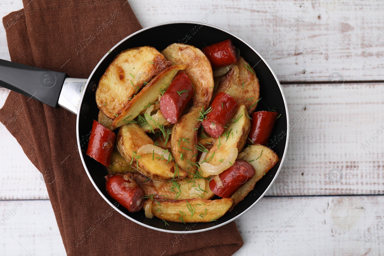 Photo of Fried potatoes with thin dry smoked sausages on white wooden table, top view