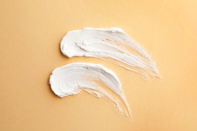 Photo of Sample facial cream on beige background, top view