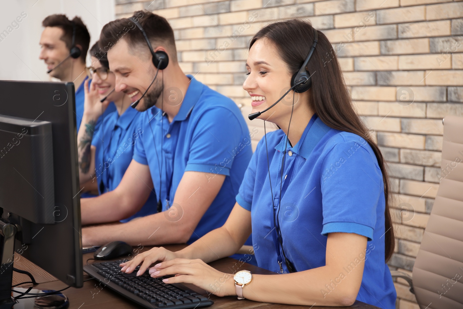 Photo of Technical support operators with headsets at workplace