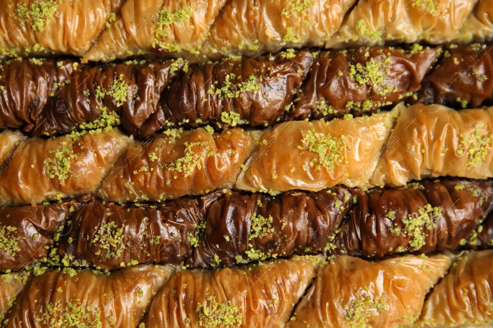 Photo of Delicious sweet baklava with pistachios as background, top view