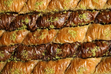 Photo of Delicious sweet baklava with pistachios as background, top view