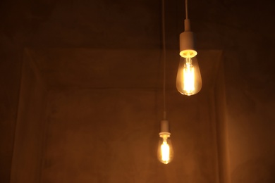 Photo of Lamp bulb in dark room. Space for text