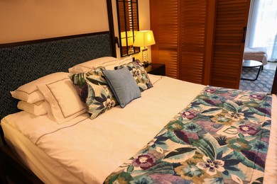 Large bed with pillows and linens in comfortable hotel room