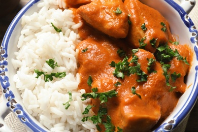 Photo of Delicious butter chicken with rice in bowl, closeup