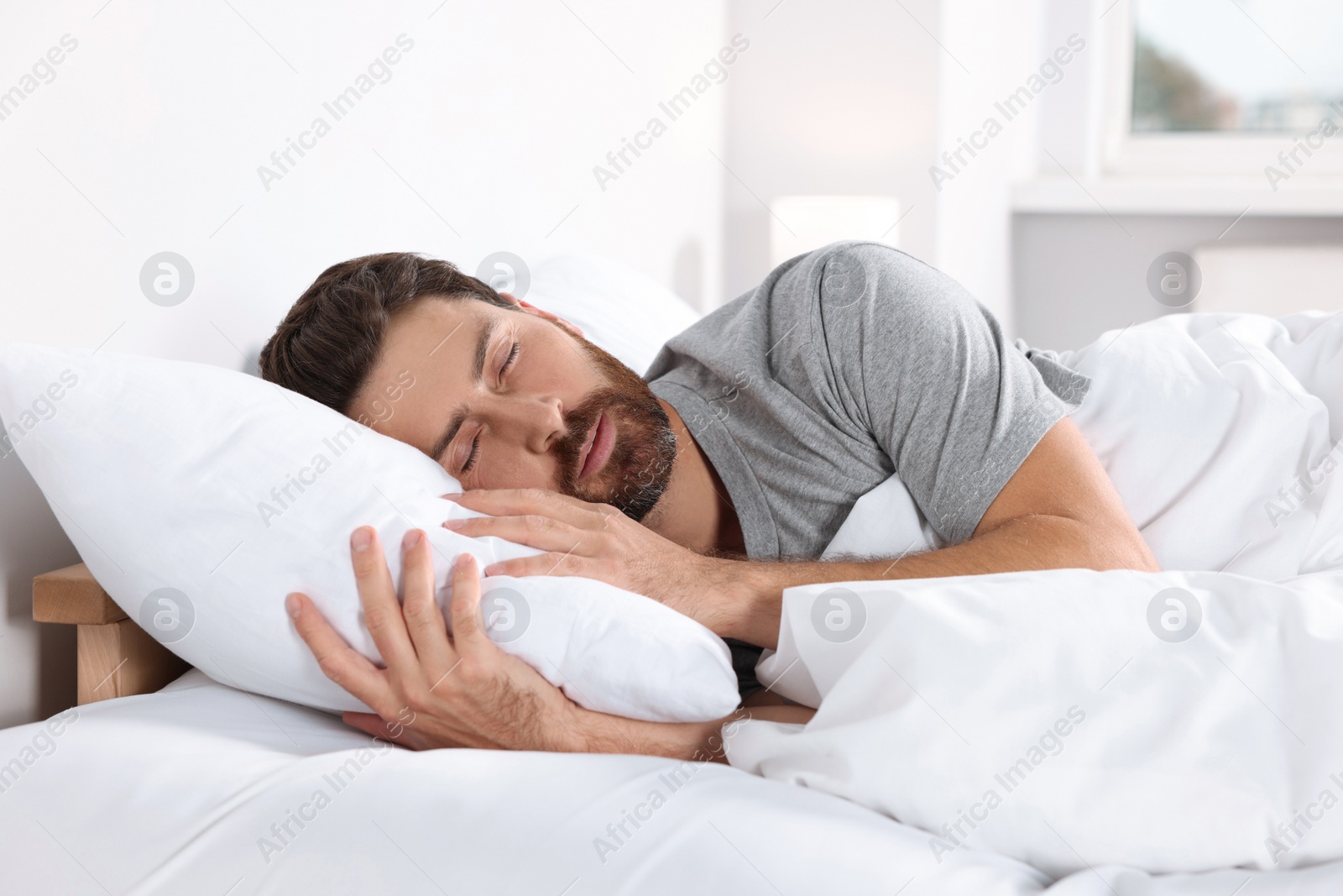 Photo of Man sleeping on comfortable pillows in bed at home