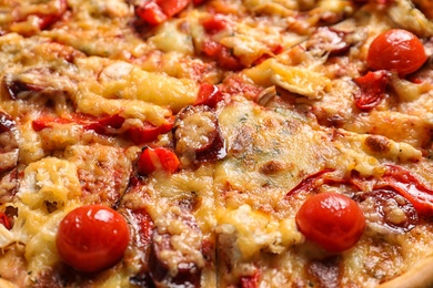 Delicious pizza with sausages and tomatoes, closeup