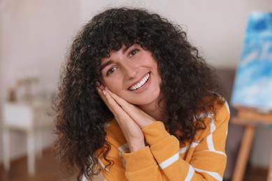 Portrait of happy young woman in stylish sweater indoors