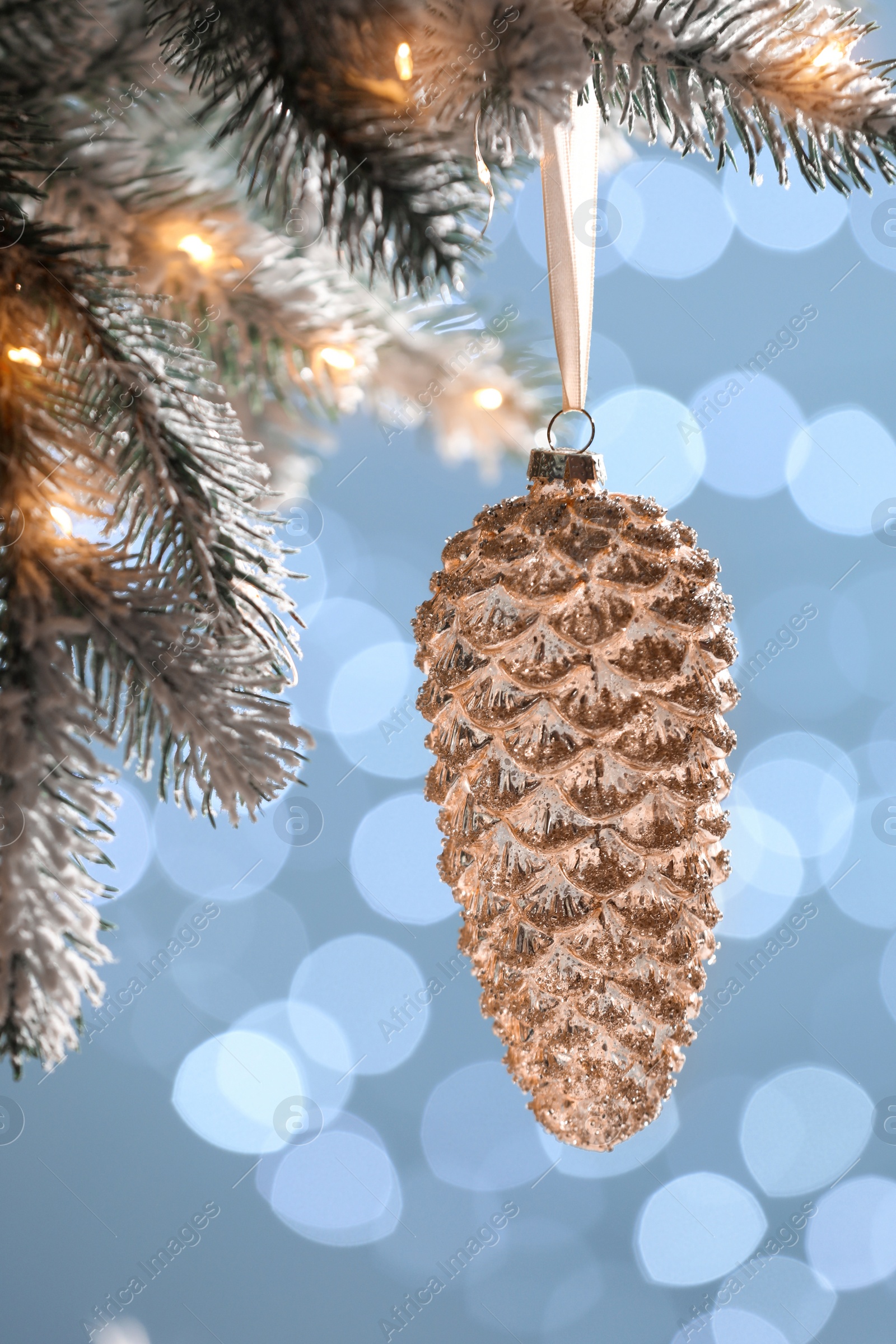 Photo of Christmas tree decorated with holiday bauble against blurred lights, closeup