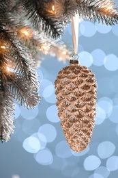 Photo of Christmas tree decorated with holiday bauble against blurred lights, closeup