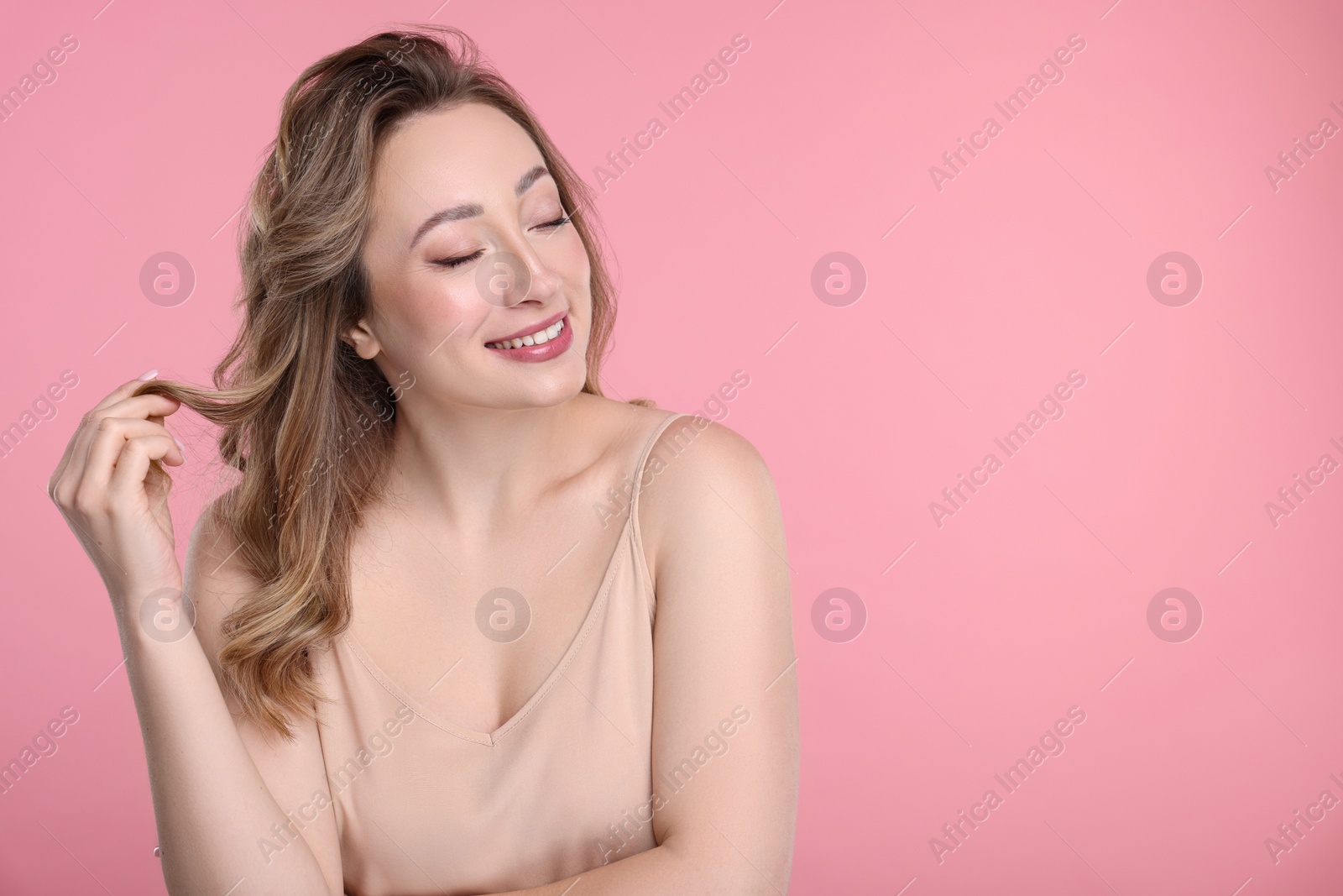 Photo of Portrait of smiling woman on pink background. Space for text