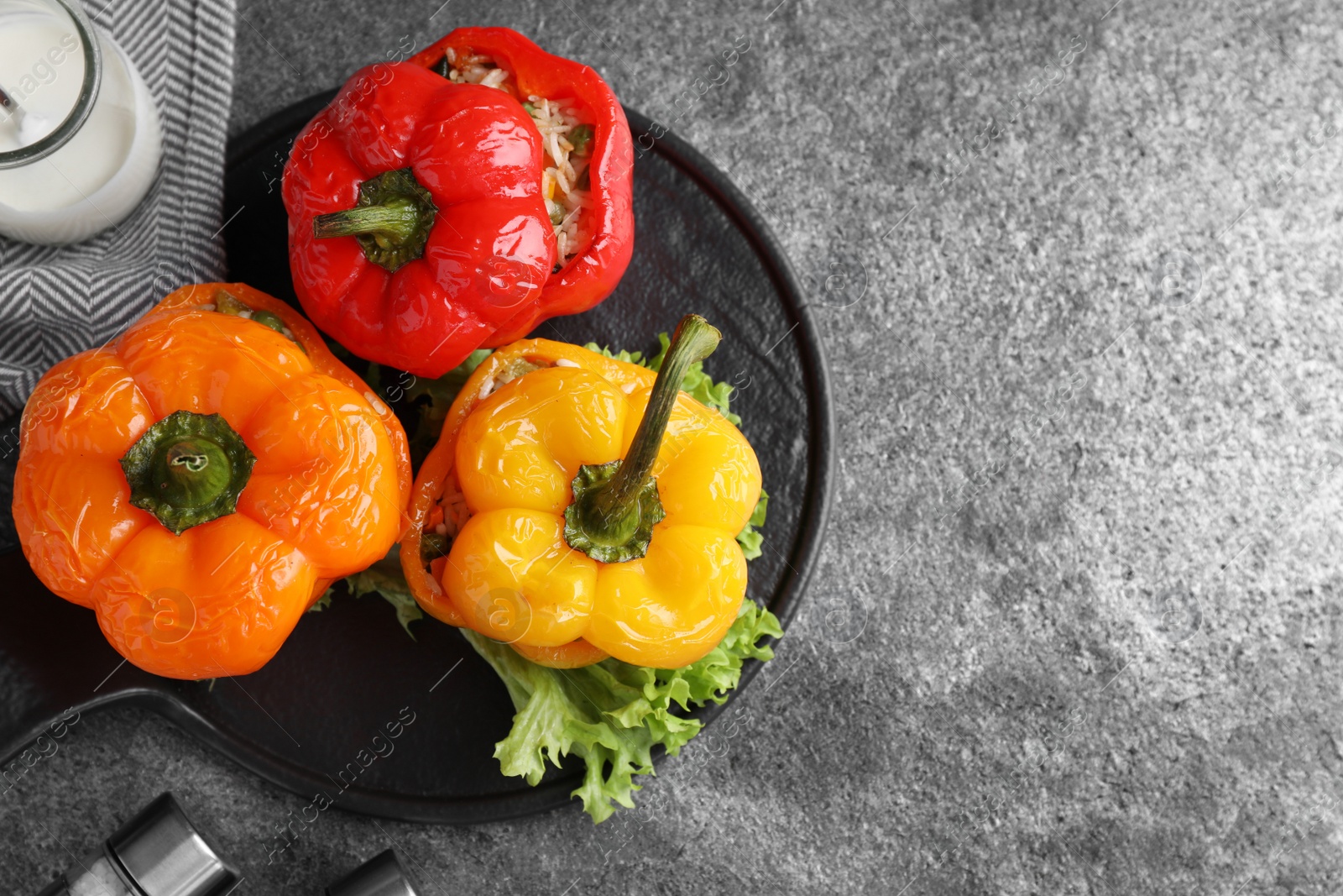 Photo of Tasty stuffed bell peppers on grey table, top view. Space for text