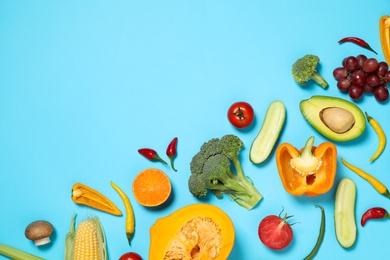 Photo of Flat lay composition with fresh organic fruits and vegetables on light blue background. Space for text