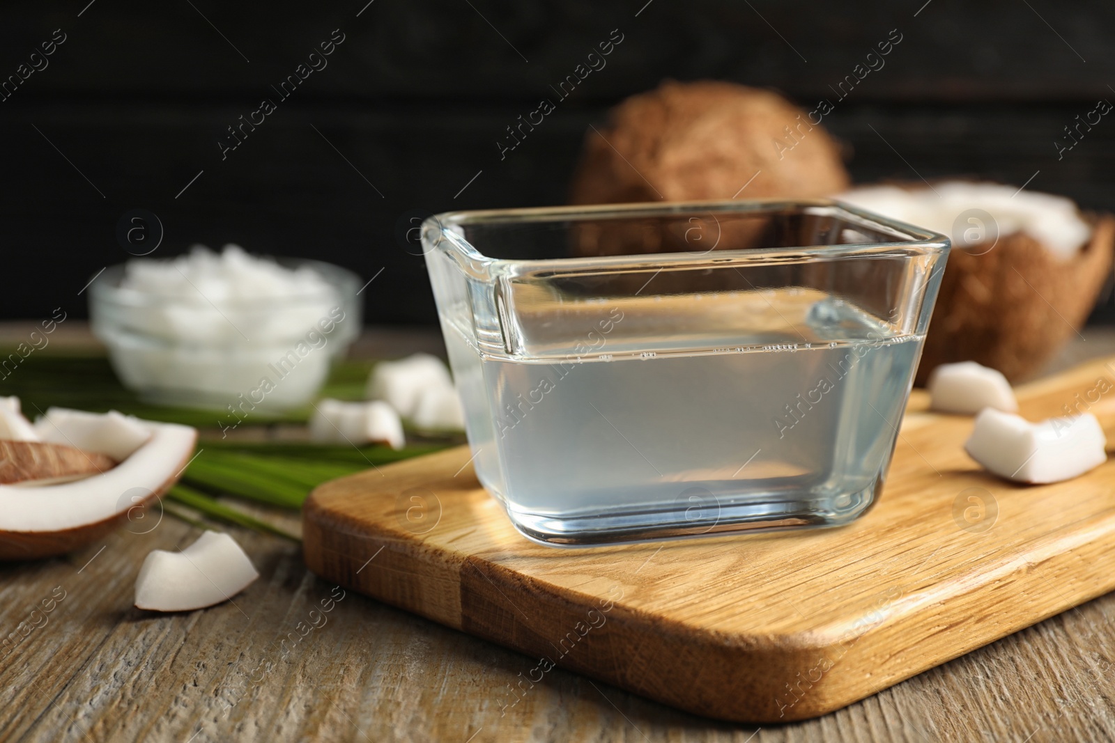 Photo of Coconut oil in bowl on wooden table