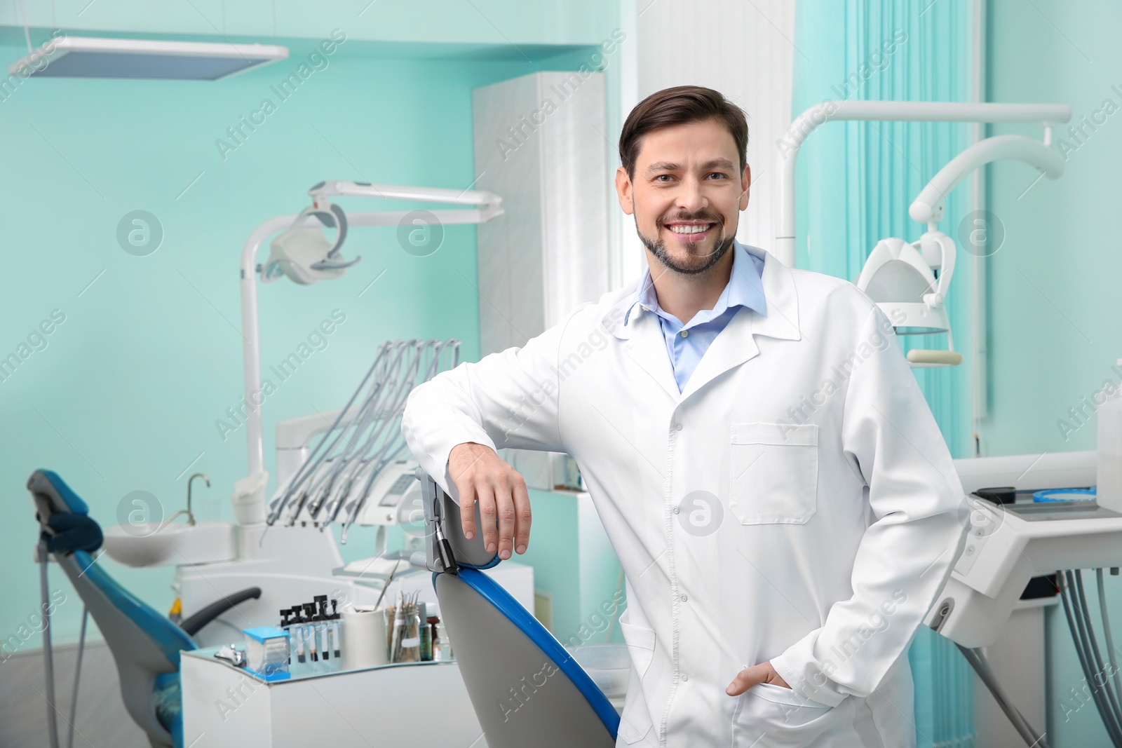 Photo of Professional male dentist in white coat at workplace. Space for text