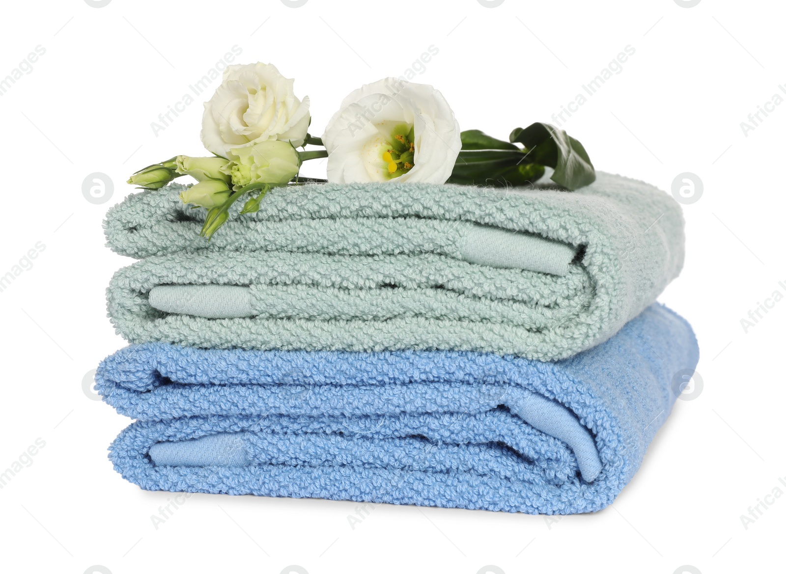 Photo of Folded clean soft towels with flowers isolated on white