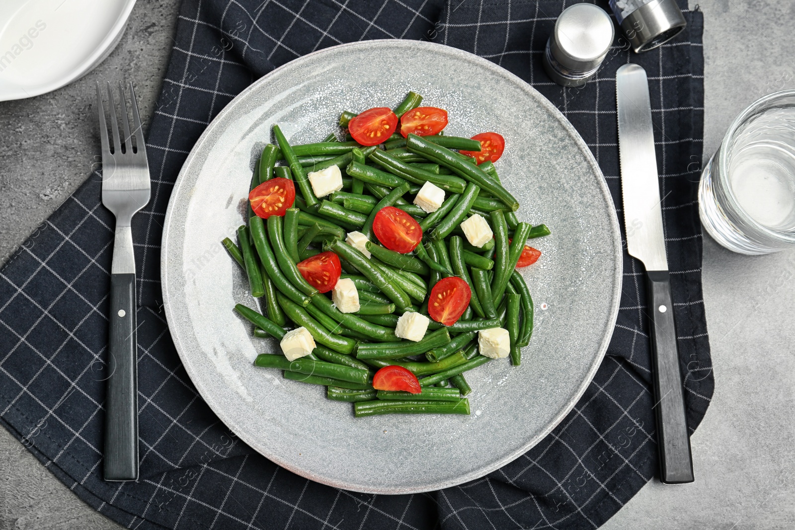 Photo of Flat lay composition with plate of fresh green bean salad on table