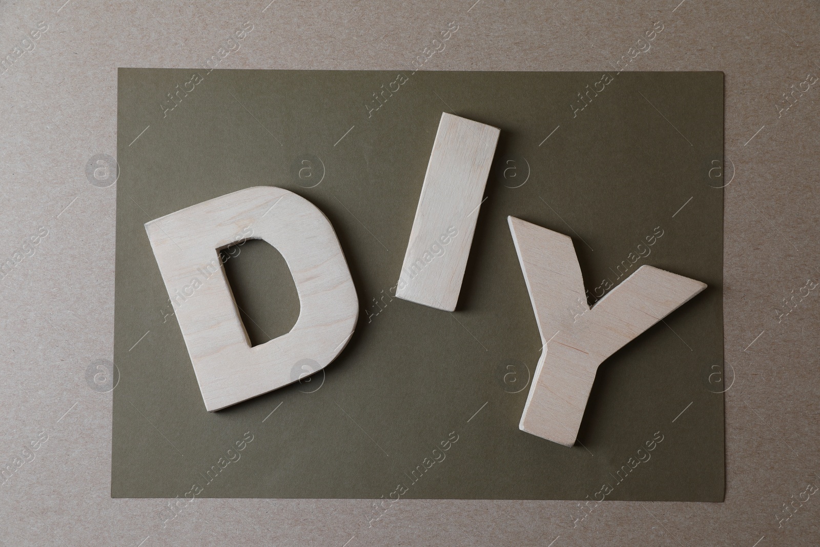 Photo of Abbreviation DIY made of wooden letters on color background, flat lay