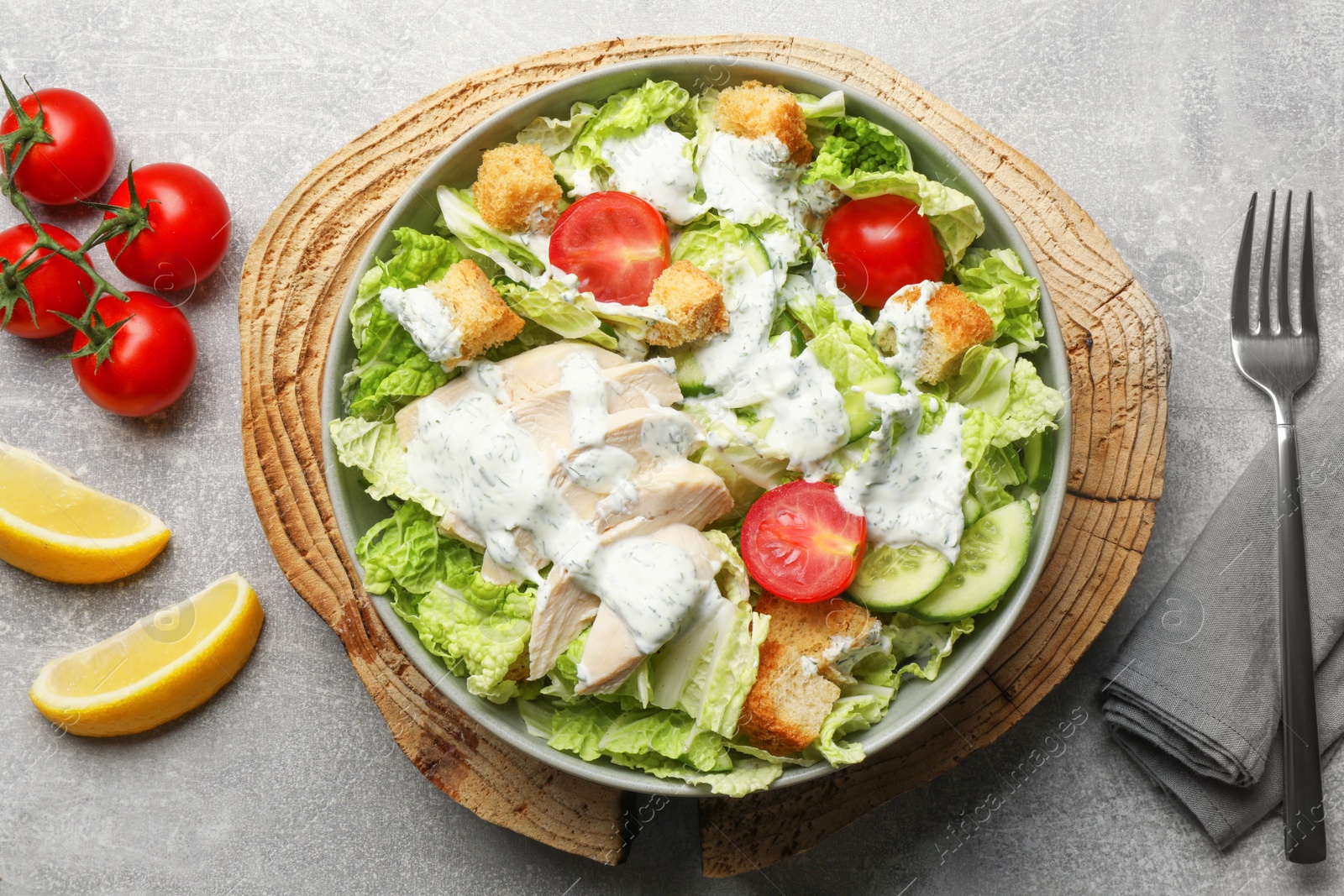 Photo of Delicious salad with Chinese cabbage, cucumber, meat and tomatoes served on grey table, flat lay