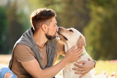 Photo of Cute yellow labrador retriever with owner outdoors