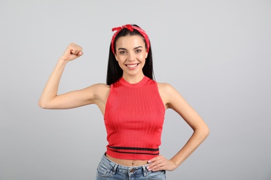 Photo of Strong woman as symbol of girl power on light grey background. 8 March concept
