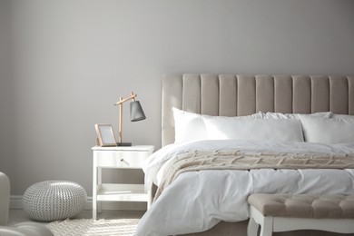 Comfortable bed with clean white linens indoors