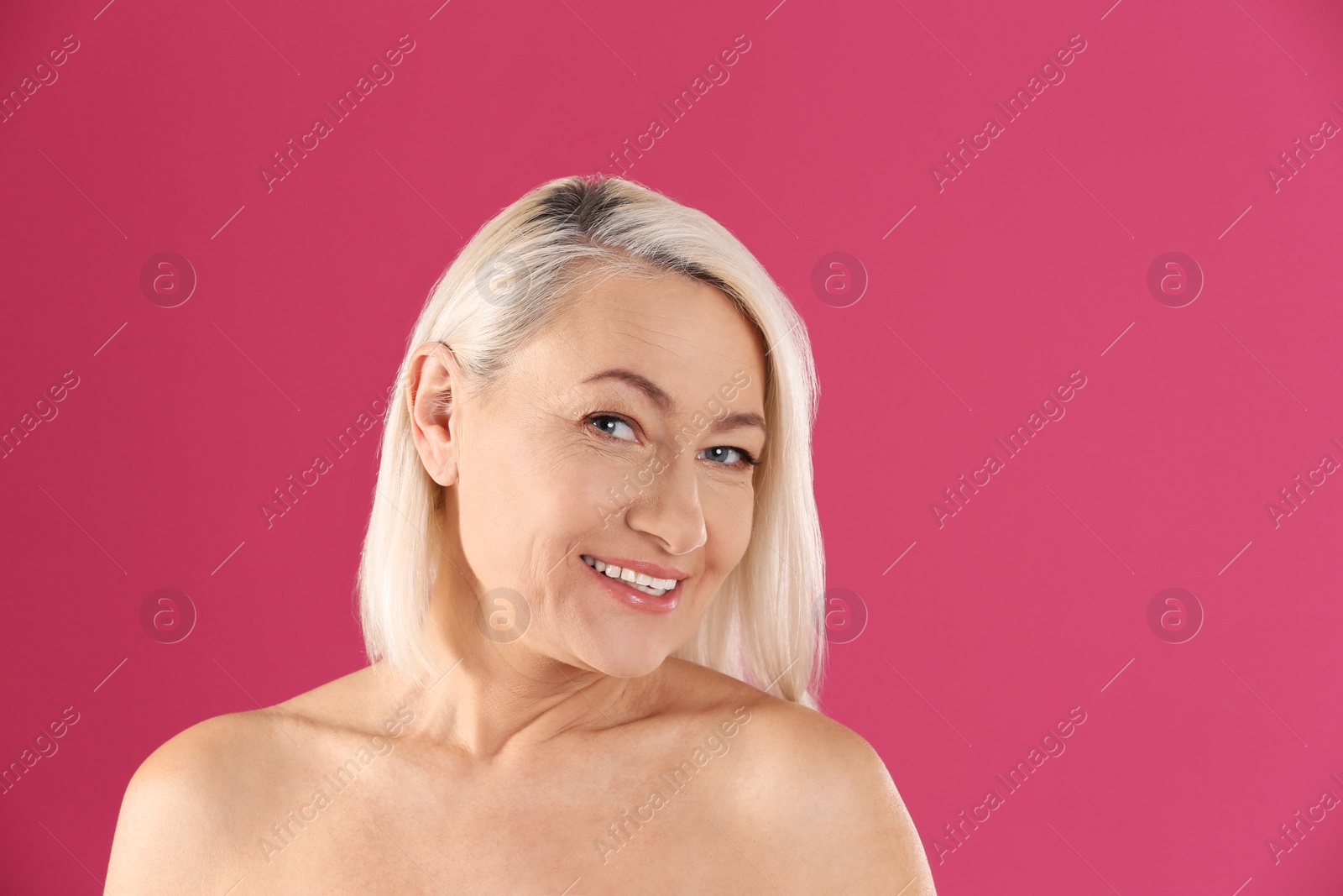 Photo of Portrait of beautiful mature woman on pink background. Space for text