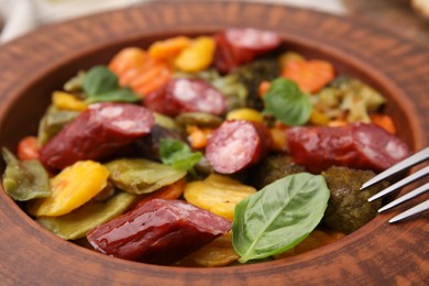 Delicious sausage and baked vegetables in bowl, closeup