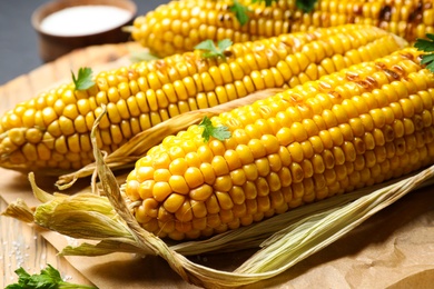 Tasty grilled corn on table, closeup view