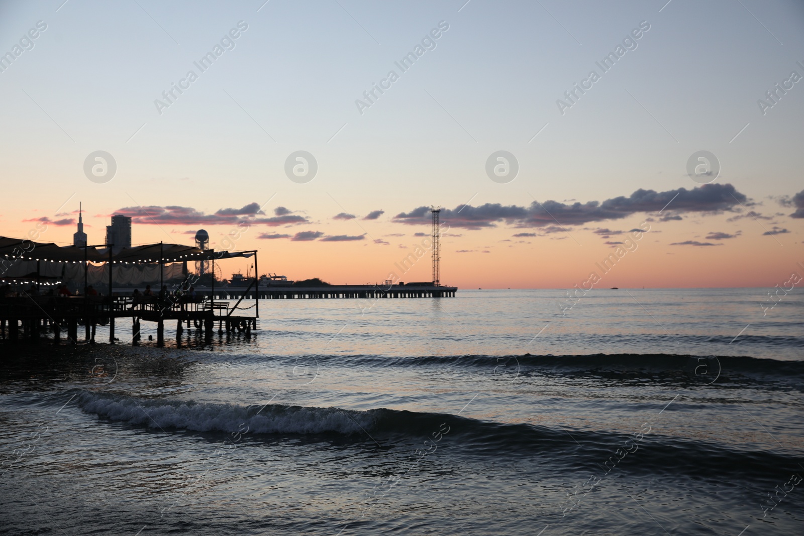 Photo of Picturesque view of port and sea under beautiful sky at sunset