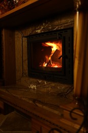 Photo of Fireplace with burning wood in darkness indoors