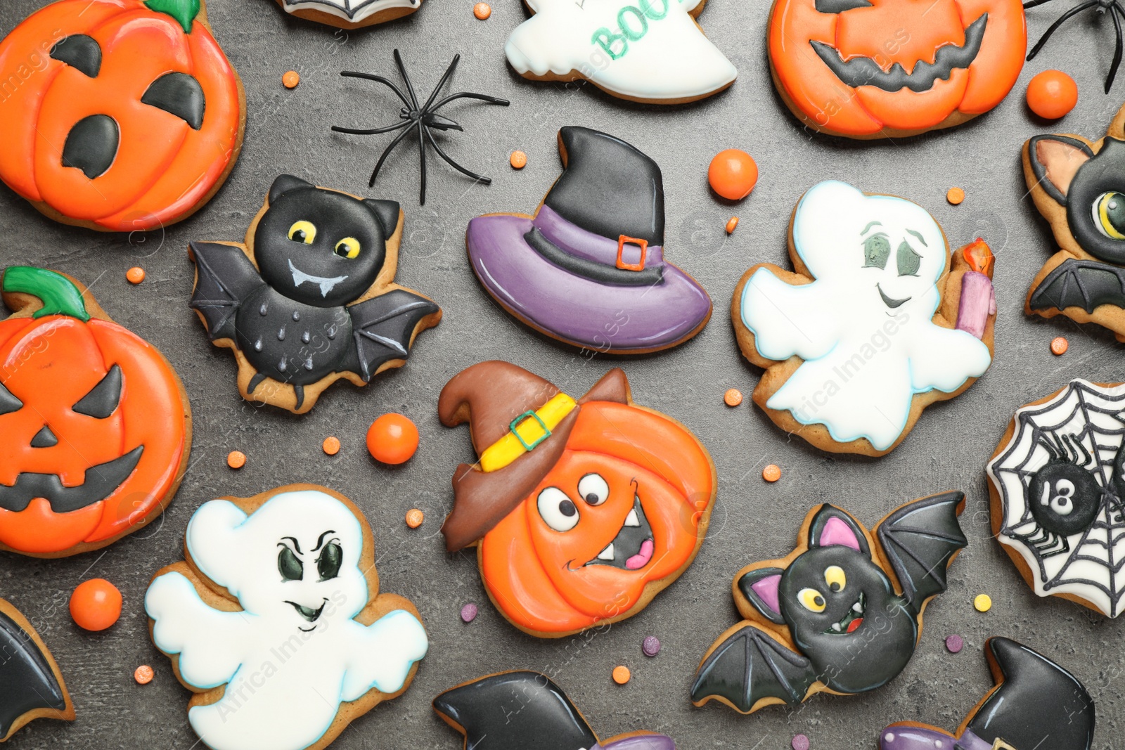 Photo of Tasty cookies and sweets for Halloween party on black table, flat lay