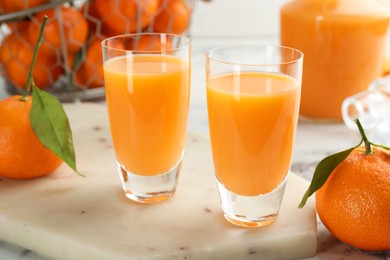 Delicious tangerine liqueur and fresh fruits on table, closeup