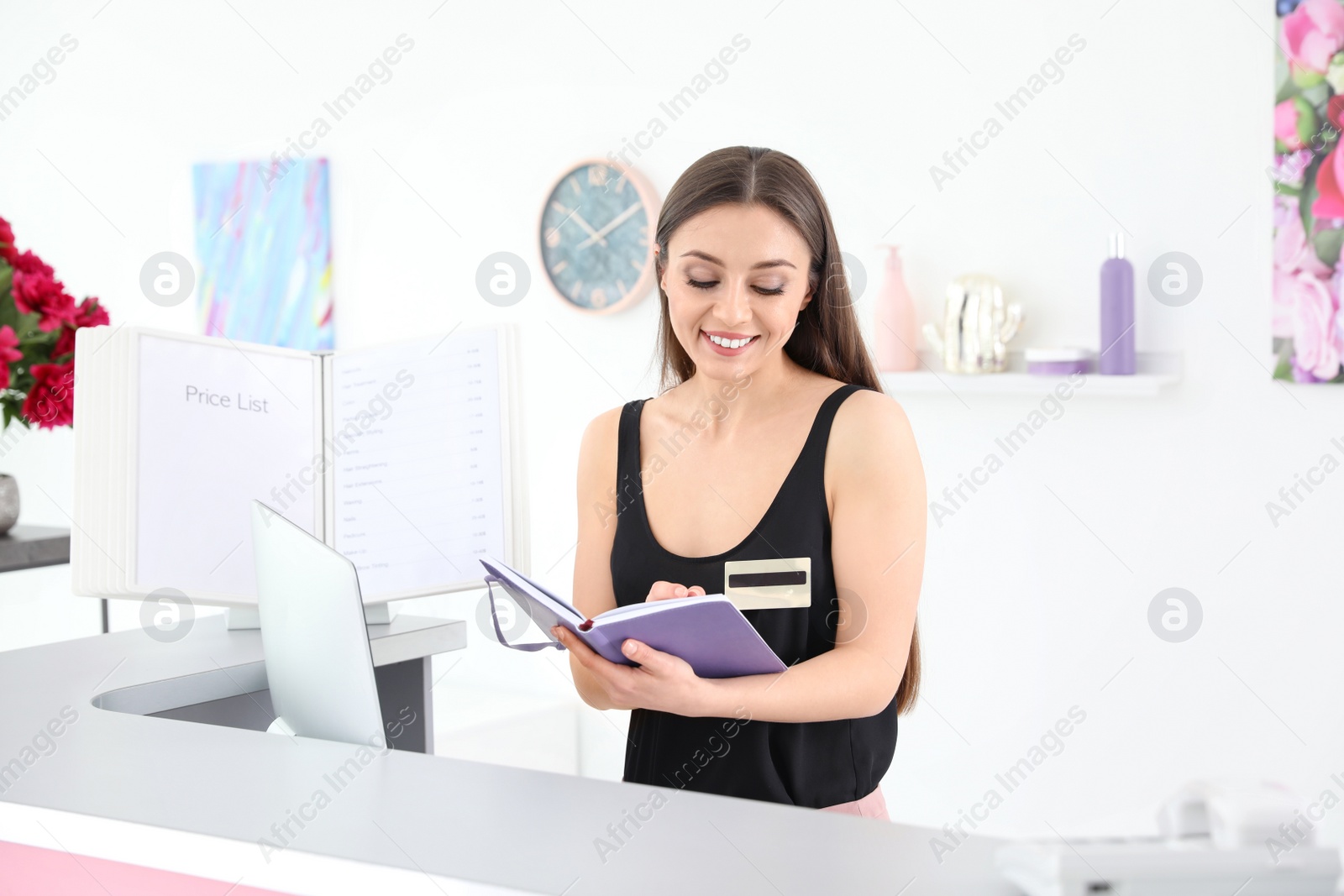 Photo of Beauty salon receptionist with notebook at desk