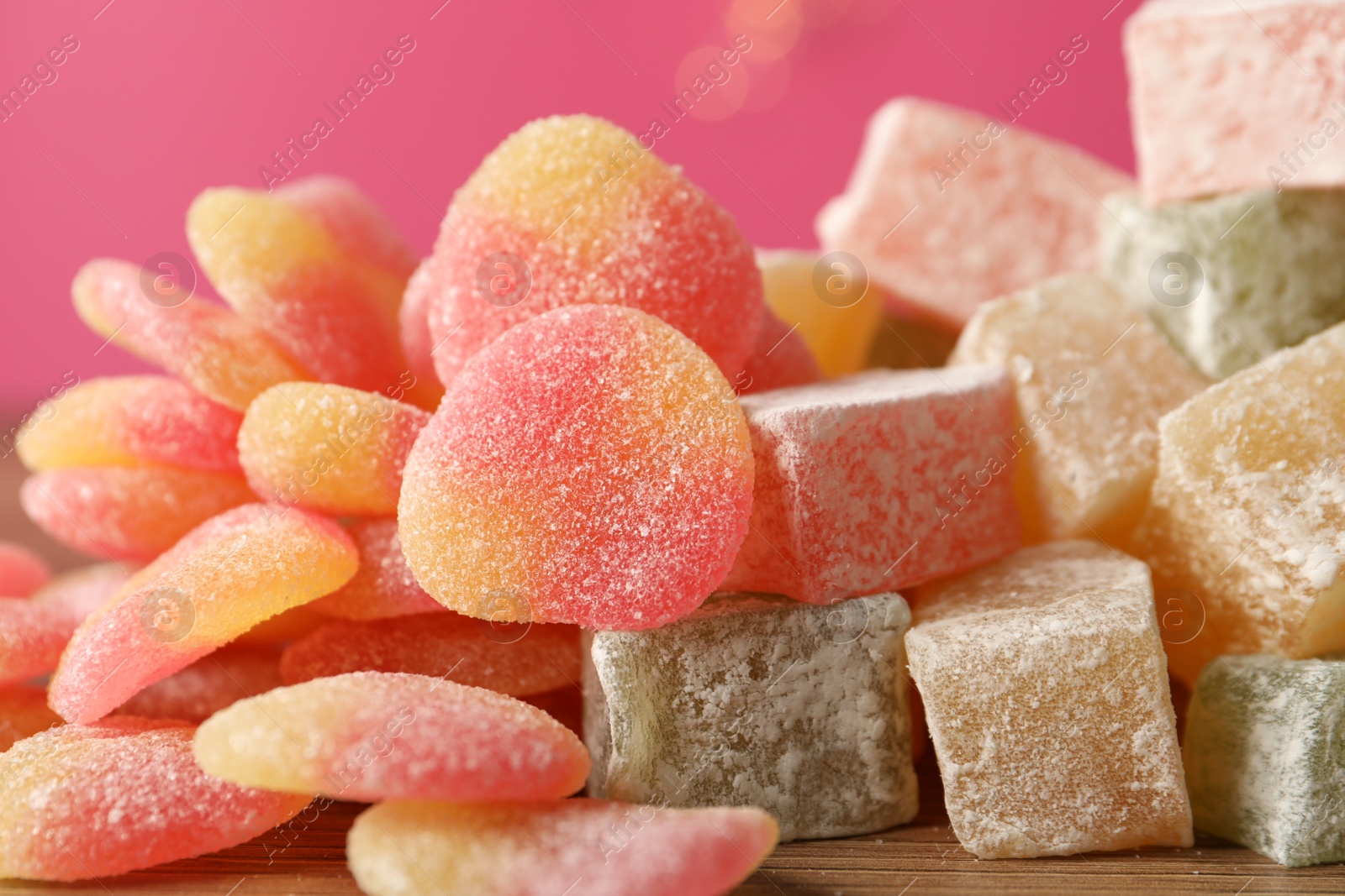 Photo of Pile of tasty sweets on pink background, closeup