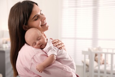 Photo of Young woman with her little baby at home. Space for text