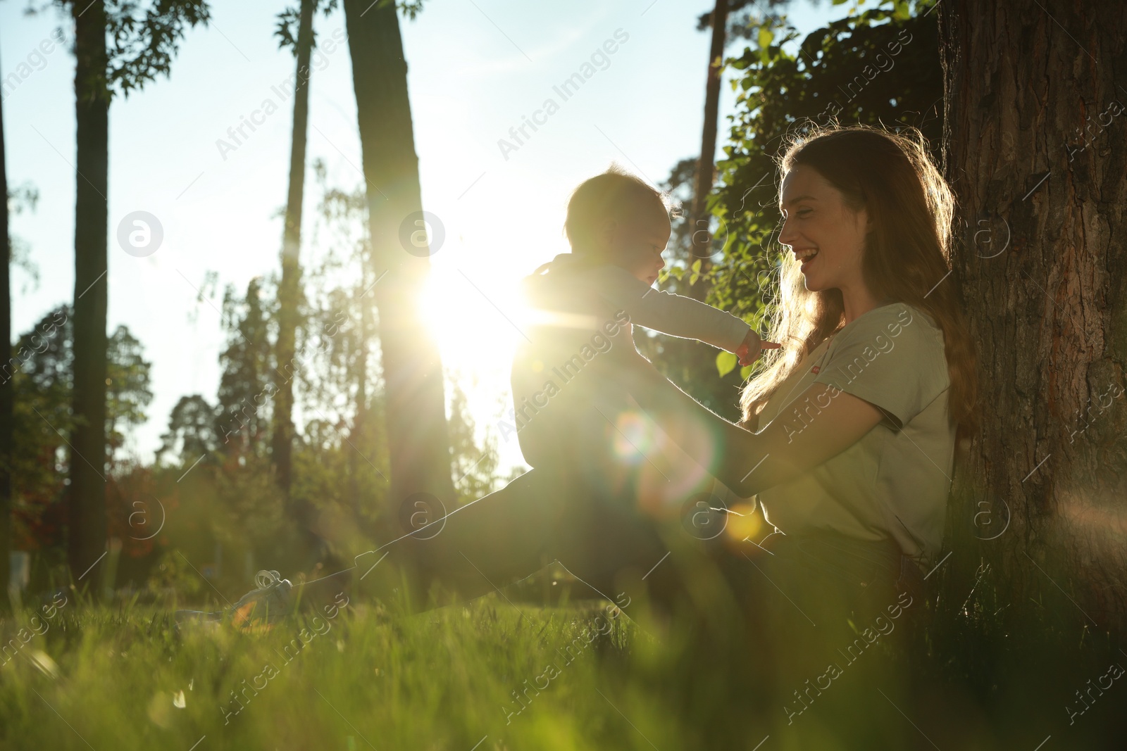 Photo of Beautiful mother with her cute daughter spending time together in park on summer day, space for text