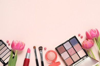 Flat lay composition with different makeup products and beautiful tulips on beige background, space for text