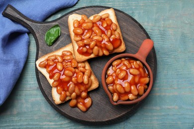 Photo of Toasts with delicious canned beans on light blue wooden table, top view