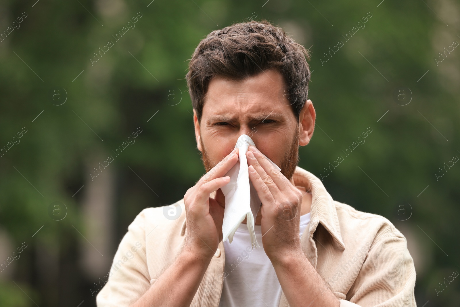 Photo of Man suffering from seasonal spring allergy outdoors