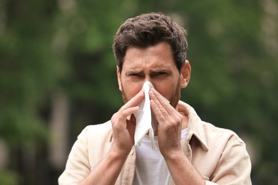 Man suffering from seasonal spring allergy outdoors