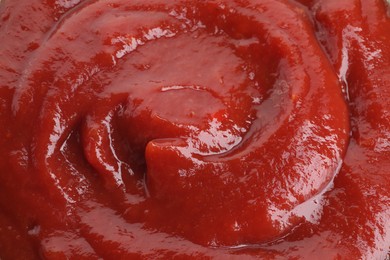 Photo of Tasty ketchup as background, closeup. Tomato sauce