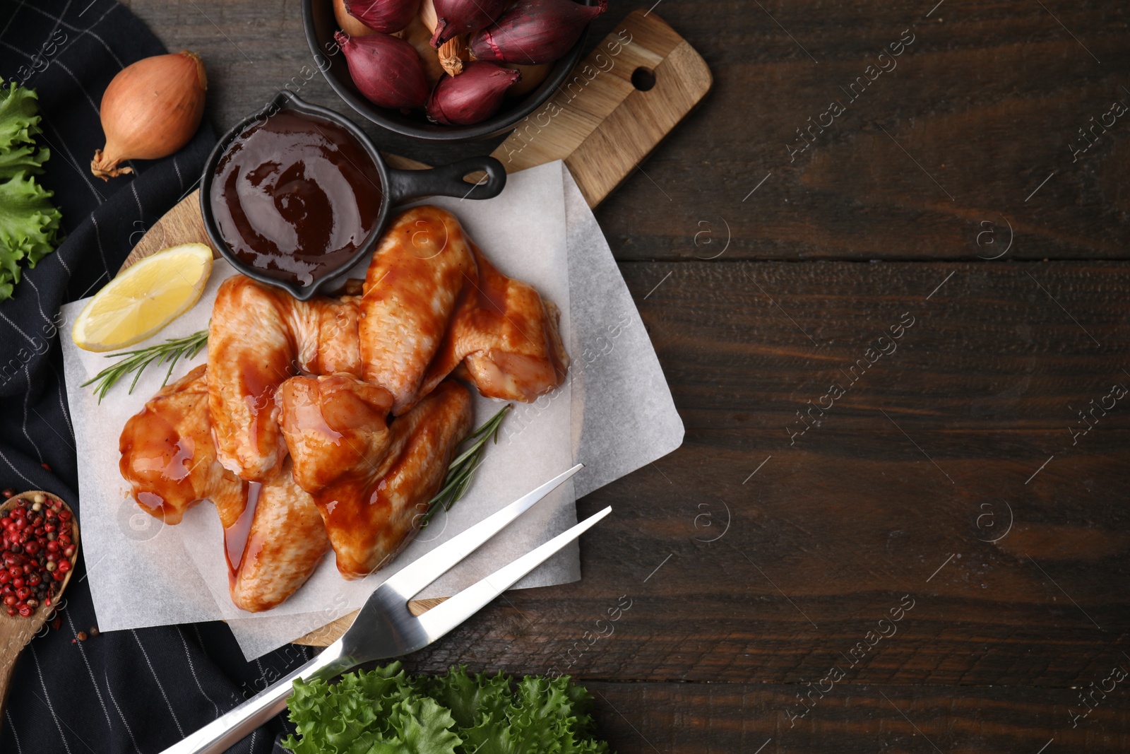 Photo of Flat lay composition with marinade, raw chicken wings and other products on wooden table. Space for text