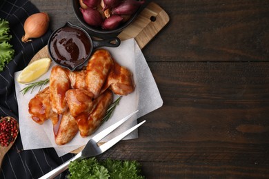 Photo of Flat lay composition with marinade, raw chicken wings and other products on wooden table. Space for text